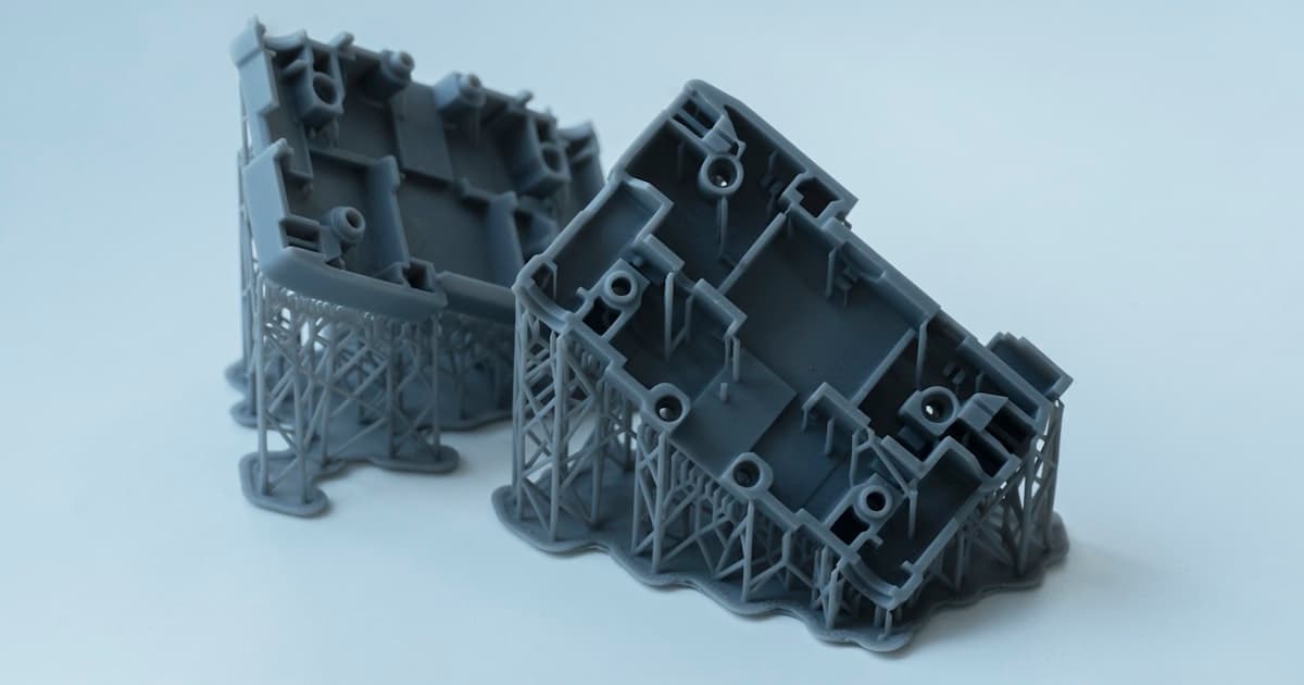 SLA resin 3D printer actively printing a complex engineering lattice structure, UV resin vat illuminated in laboratory setting